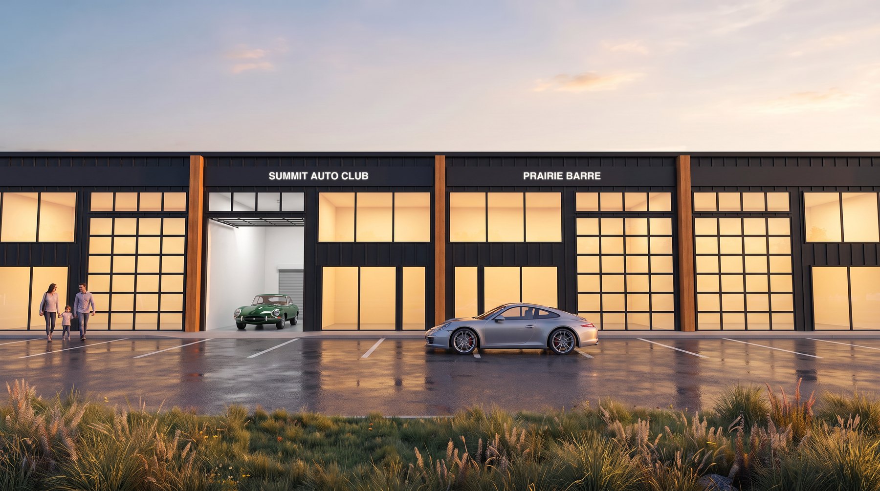 A suite at dusk with its glass overhead door raised, a vintage sports car inside and a modern sports car in front